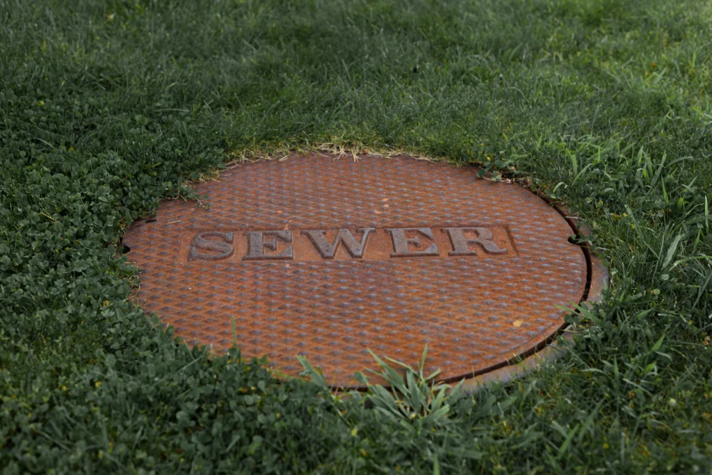 Rusty sewer cover in grassy area